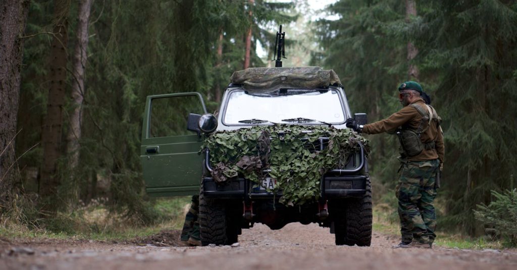 Soldier in camouflage operates an armored vehicle in a dense forest, showcasing military readiness.
